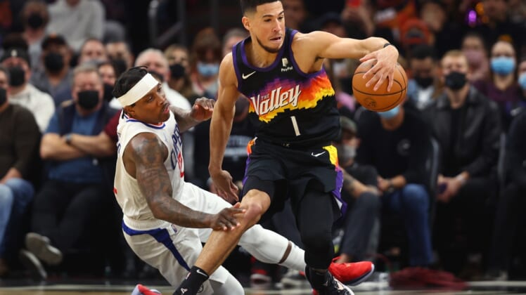 Jan 6, 2022; Phoenix, Arizona, USA; Phoenix Suns guard Devin Booker (1) moves the ball against Los Angeles Clippers guard Eric Bledsoe (12) in the first half at Footprint Center. Mandatory Credit: Mark J. Rebilas-USA TODAY Sports