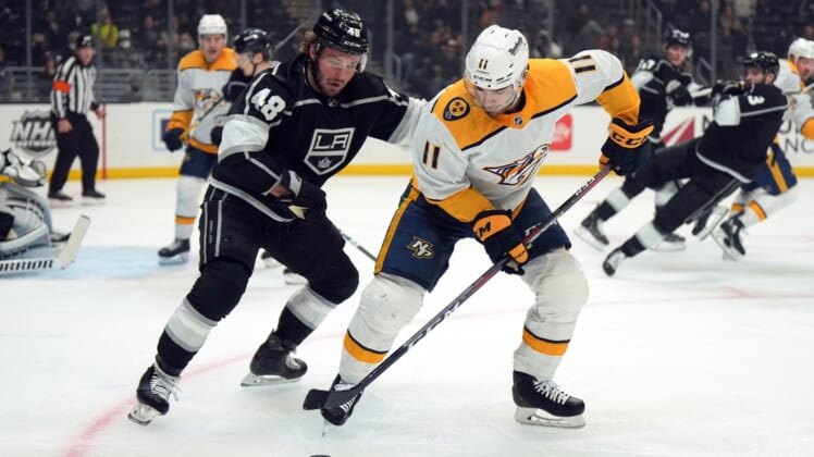 Jan 6, 2022; Los Angeles, California, USA; Nashville Predators center Luke Kunin (11) and LA Kings left wing Brendan Lemieux (48) reach for the puck in the first period at Crypto.com Arena. Mandatory Credit: Kirby Lee-USA TODAY Sports