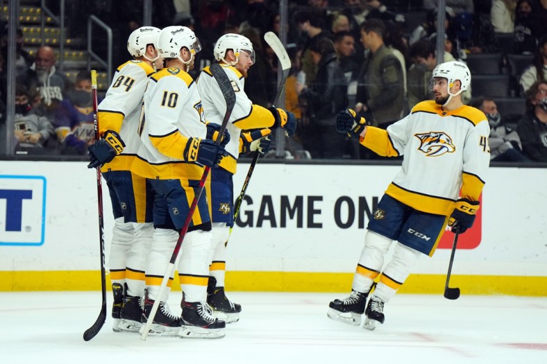Jan 6, 2022; Los Angeles, California, USA; Nashville Predators left wing Tanner Jeannot (84) and center Colton Sissons (10), center Yakov Trenin (13) and defenseman Alexandre Carrier (45) celebrate after a goal against the LA Kings in the third period at Crypto.com Arena. Mandatory Credit: Kirby Lee-USA TODAY Sports