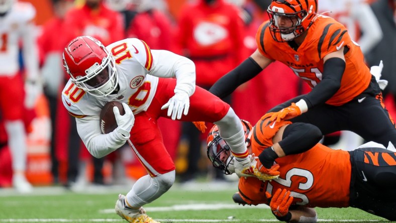 Jan 2, 2022; Cincinnati, Ohio, USA; Kansas City Chiefs wide receiver Tyreek Hill (10) runs with the ball against Cincinnati Bengals linebacker Logan Wilson (55) in the first half at Paul Brown Stadium. Mandatory Credit: Katie Stratman-USA TODAY Sports