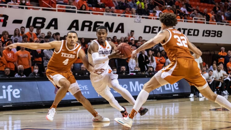Jan 8, 2022; Stillwater, Oklahoma, USA; Oklahoma State Cowboys guard Bryce Thompson (1) drives to the basket while defended by Texas Longhorns forward Dylan Disu (4) during the first half at Gallagher-Iba Arena. Mandatory Credit: Rob Ferguson-USA TODAY Sports