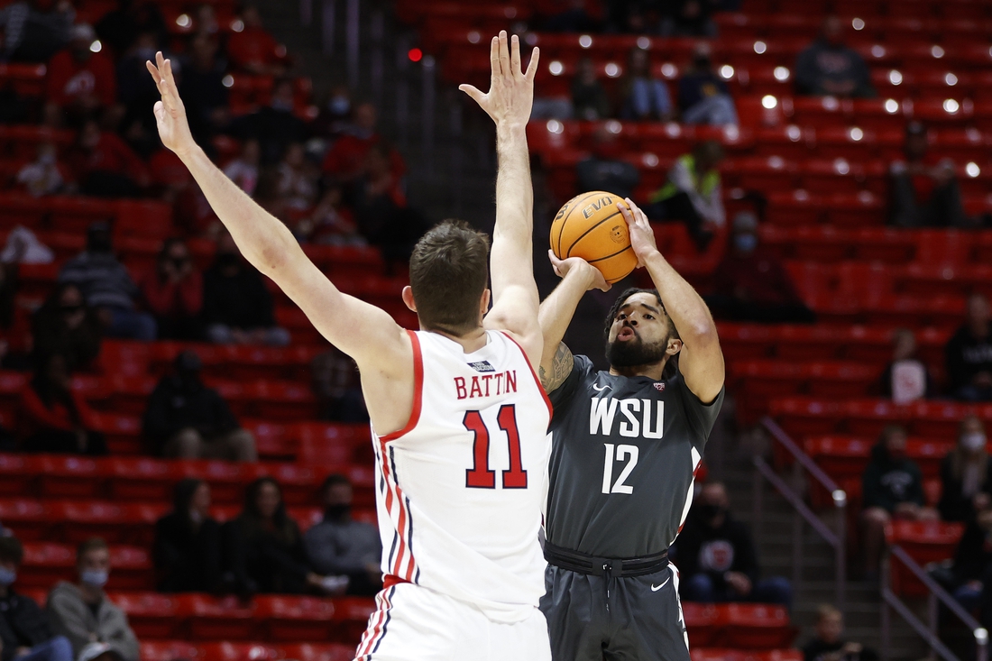 Jan 8, 2022; Salt Lake City, Utah, USA; Washington State Cougars guard Michael Flowers (12) shoots against Utah Utes forward Riley Battin (11) in the first half at Jon M. Huntsman Center. Mandatory Credit: Jeffrey Swinger-USA TODAY Sports