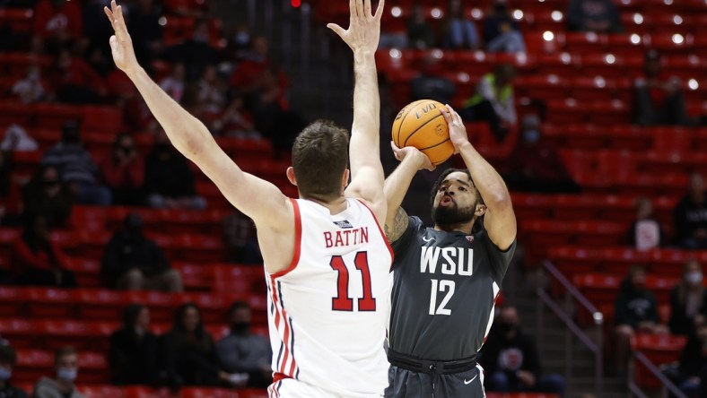 Jan 8, 2022; Salt Lake City, Utah, USA; Washington State Cougars guard Michael Flowers (12) shoots against Utah Utes forward Riley Battin (11) in the first half at Jon M. Huntsman Center. Mandatory Credit: Jeffrey Swinger-USA TODAY Sports