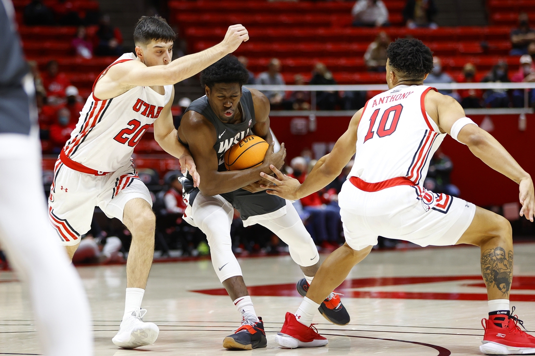 Jan 8, 2022; Salt Lake City, Utah, USA; Washington State Cougars guard T.J. Bamba (5) drives against Utah Utes guard Lazar Stefanovic (20) and guard David Jenkins Jr. (1) in the first half at Jon M. Huntsman Center. Mandatory Credit: Jeffrey Swinger-USA TODAY Sports