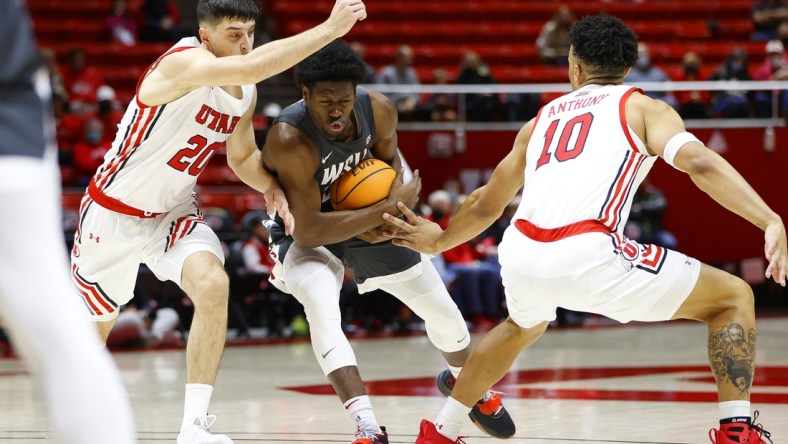 Jan 8, 2022; Salt Lake City, Utah, USA; Washington State Cougars guard T.J. Bamba (5) drives against Utah Utes guard Lazar Stefanovic (20) and guard David Jenkins Jr. (1) in the first half at Jon M. Huntsman Center. Mandatory Credit: Jeffrey Swinger-USA TODAY Sports