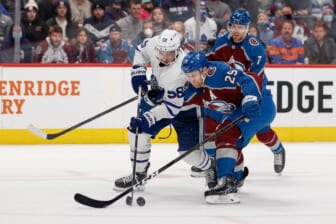 Jan 8, 2022; Denver, Colorado, USA; Toronto Maple Leafs left wing Michael Bunting (58) and Colorado Avalanche center Nathan MacKinnon (29) battle for the puck in the first period at Ball Arena. Mandatory Credit: Isaiah J. Downing-USA TODAY Sports