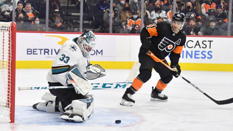 Jan 8, 2022; Philadelphia, Pennsylvania, USA; San Jose Sharks goaltender Adin Hill (33) makes a save as Philadelphia Flyers center Scott Laughton (21) looks on during the second period at Wells Fargo Center. Mandatory Credit: Eric Hartline-USA TODAY Sports