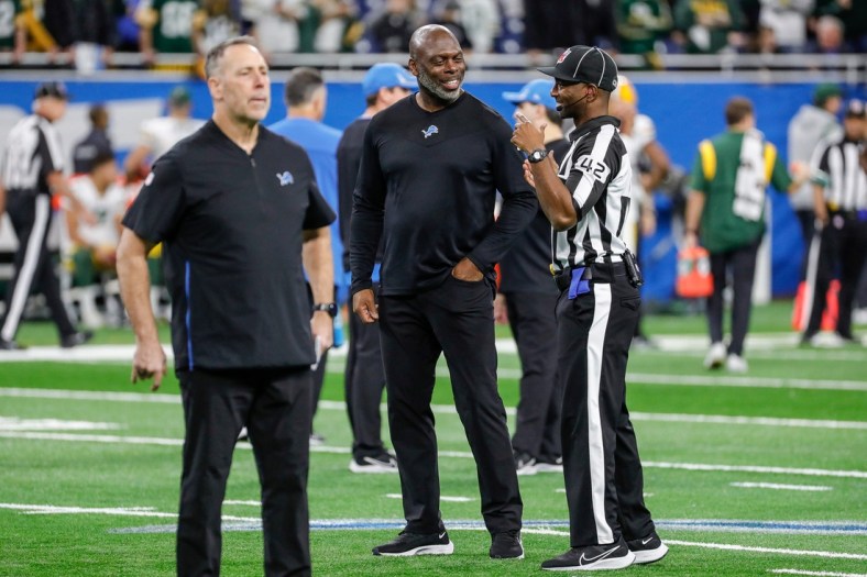 Lions offensive coordinator Anthony Lynn, center, speaks to a game official during warmups before the game against the Packers on Sunday, Jan. 9, 2022, at Ford Field.