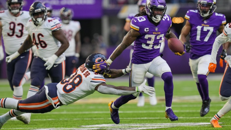 Jan 9, 2022; Minneapolis, Minnesota, USA; Minnesota Vikings running back Dalvin Cook (33) runs with the ball against the Chicago Bears safety Tashaun Gipson (38) in the fourth quarter at U.S. Bank Stadium. Mandatory Credit: Brad Rempel-USA TODAY Sports