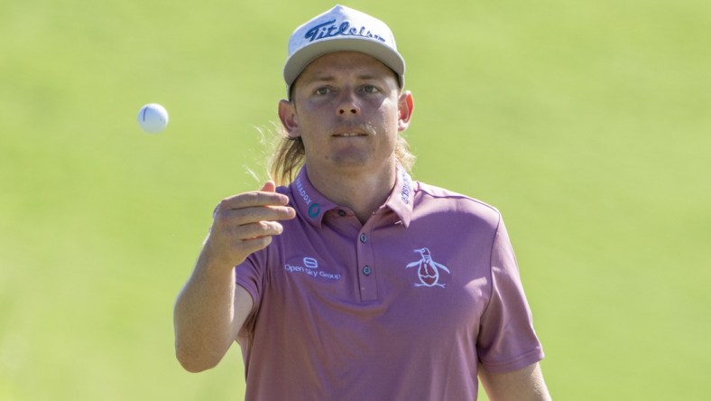 January 9, 2022; Maui, Hawaii, USA; Cameron Smith tosses his ball to his caddie on the first hole during the final round of the Sentry Tournament of Champions golf tournament at Kapalua Resort - The Plantation Course. Mandatory Credit: Kyle Terada-USA TODAY Sports