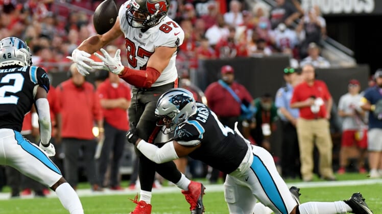 Jan 9, 2022; Tampa, Florida, USA;  Tampa Bay Buccaneers tight end Rob Gronkowski (87) juggles the ball as Carolina Panthers linebacker Jermaine Carter Jr. (4) attempts to make the tackle  in the first half at Raymond James Stadium. Mandatory Credit: Jonathan Dyer-USA TODAY Sports
