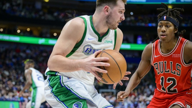 Jan 9, 2022; Dallas, Texas, USA; Dallas Mavericks guard Luka Doncic (77) grabs a rebound in front of Chicago Bulls guard Ayo Dosunmu (12) during the second quarter at the American Airlines Center. Mandatory Credit: Jerome Miron-USA TODAY Sports