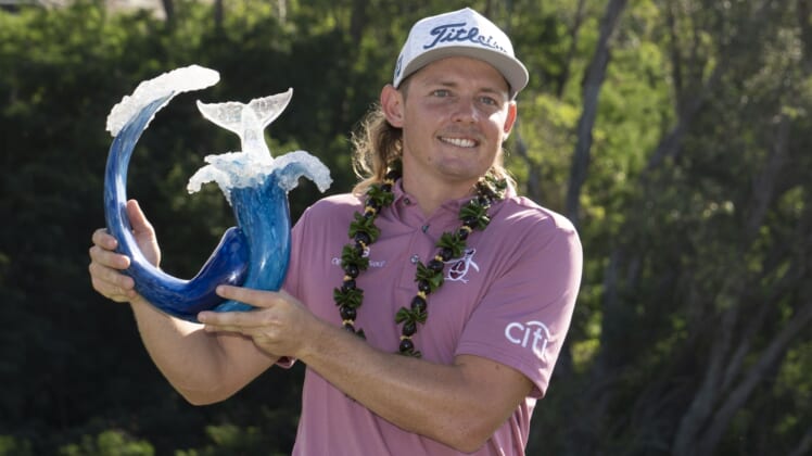 January 9, 2022; Maui, Hawaii, USA; Cameron Smith hoists the trophy after winning during the final round of the Sentry Tournament of Champions golf tournament at Kapalua Resort - The Plantation Course. Mandatory Credit: Kyle Terada-USA TODAY Sports