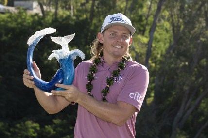 January 9, 2022; Maui, Hawaii, USA; Cameron Smith hoists the trophy after winning during the final round of the Sentry Tournament of Champions golf tournament at Kapalua Resort - The Plantation Course. Mandatory Credit: Kyle Terada-USA TODAY Sports