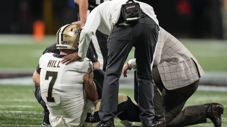 Jan 9, 2022; Atlanta, Georgia, USA; New Orleans Saints quarterback Taysom Hill (7) is checked after being injured running against the Atlanta Falcons during the first half at Mercedes-Benz Stadium. Mandatory Credit: Dale Zanine-USA TODAY Sports