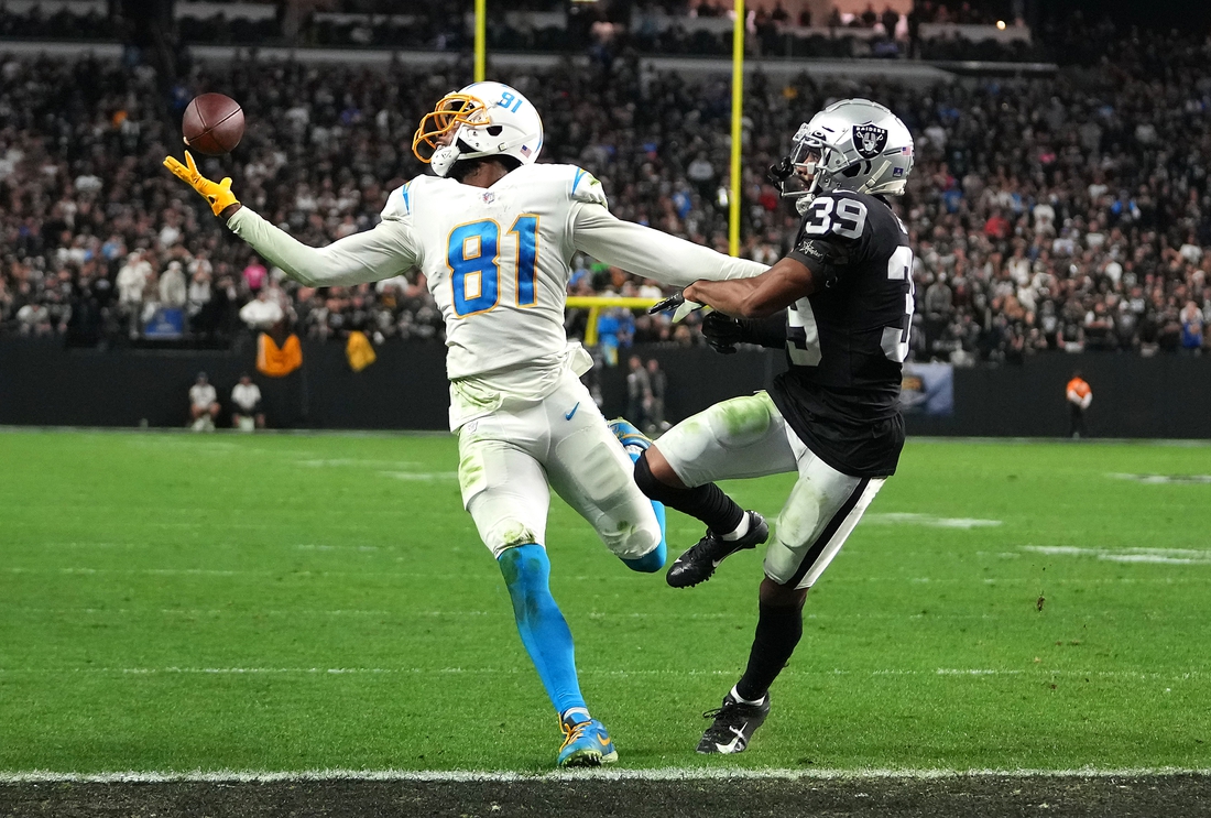 Jan 9, 2022; Paradise, Nevada, USA; Los Angeles Chargers wide receiver Mike Williams (81) reaches for a pass as Las Vegas Raiders cornerback Nate Hobbs (39) defends during an overtime period at Allegiant Stadium. Mandatory Credit: Stephen R. Sylvanie-USA TODAY Sports