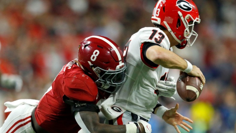 Alabama Crimson Tide linebacker Christian Harris (8) causes Georgia Bulldogs quarterback Stetson Bennett (13) to fumble and turn over the ball Monday, Jan. 10, 2022, during the College Football Playoff National Championship at Lucas Oil Stadium in Indianapolis.