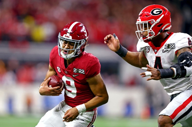 Jan 10, 2022; Indianapolis, IN, USA; Alabama Crimson Tide quarterback Bryce Young (9) runs the ball against Georgia Bulldogs linebacker Nolan Smith (4) during the second half in the 2022 CFP college football national championship game at Lucas Oil Stadium. Mandatory Credit: Mark J. Rebilas-USA TODAY Sports