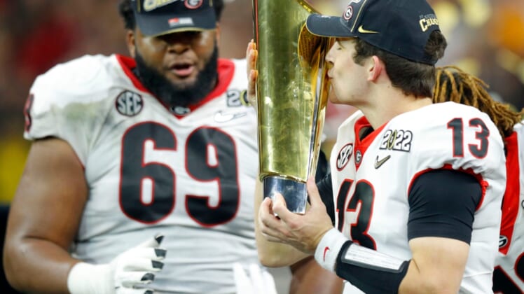 Georgia Bulldogs quarterback Stetson Bennett (13) kisses the trophy Tuesday, Jan. 11, 2022, after defeating Alabama in the College Football Playoff National Championship at Lucas Oil Stadium in Indianapolis.