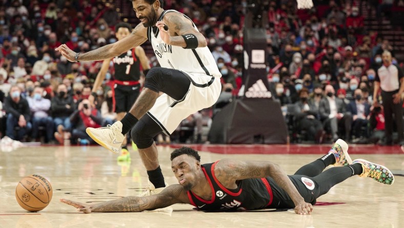 Jan 10, 2022; Portland, Oregon, USA; Portland Trail Blazers forward Nassir Little (9) dives for a loose ball during the second half against Brooklyn Nets guard Kyrie Irving (11) at Moda Center. The Trail Blazers won the game 114-108. Mandatory Credit: Troy Wayrynen-USA TODAY Sports