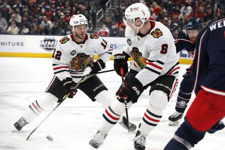 Jan 11, 2022; Columbus, Ohio, USA; Chicago Blackhawks right wing Alex DeBrincat (12) controls the puck against the Columbus Blue Jackets during the second period at Nationwide Arena. Mandatory Credit: Russell LaBounty-USA TODAY Sports