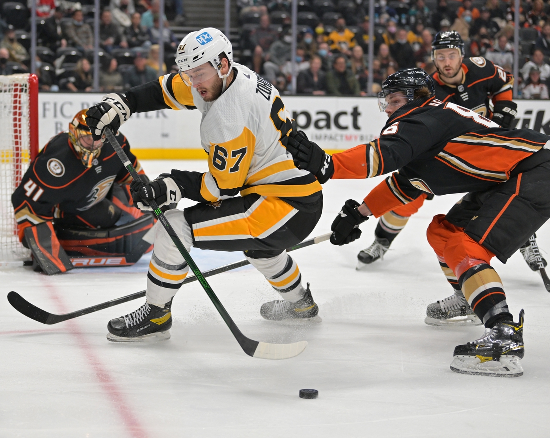 Jan 11, 2022; Anaheim, California, USA; Pittsburgh Penguins left wing Radim Zohorna (67) and Anaheim Ducks defenseman Simon Benoit (86) battle for the puck in the second half at Honda Center. Mandatory Credit: Jayne Kamin-Oncea-USA TODAY Sports