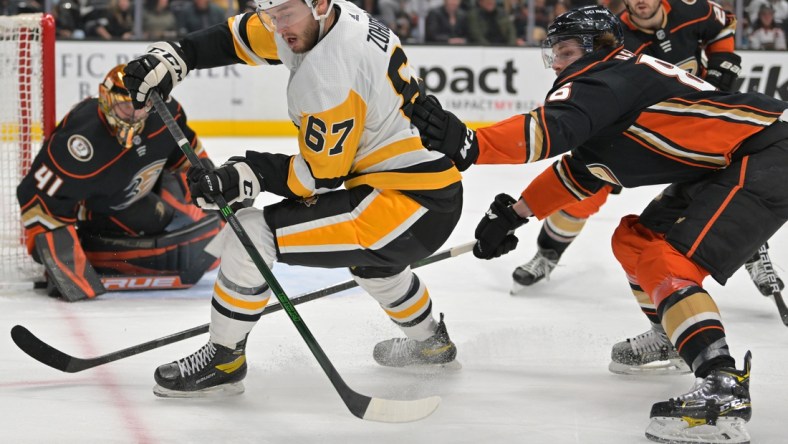 Jan 11, 2022; Anaheim, California, USA; Pittsburgh Penguins left wing Radim Zohorna (67) and Anaheim Ducks defenseman Simon Benoit (86) battle for the puck in the second half at Honda Center. Mandatory Credit: Jayne Kamin-Oncea-USA TODAY Sports