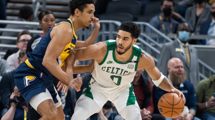 Jan 12, 2022; Indianapolis, Indiana, USA; Boston Celtics forward Jayson Tatum (0) dribbles the ball while Indiana Pacers guard Malcolm Brogdon (7) defends in the first quarter at Gainbridge Fieldhouse. Mandatory Credit: Trevor Ruszkowski-USA TODAY Sports
