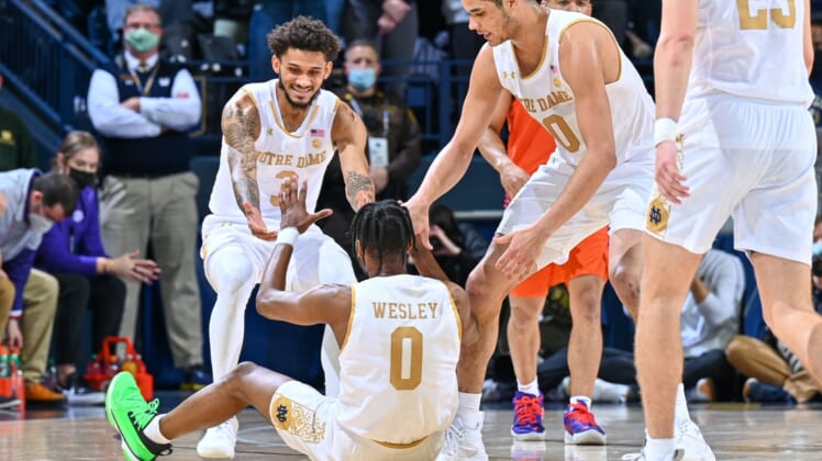 Jan 12, 2022; South Bend, Indiana, USA; Notre Dame Fighting Irish guard Blake Wesley (0) is helped up by guard Prentiss Hubb (3) and forward Paul Atkinson Jr. (20) after he was fouled in the first half against the Clemson Tigers at the Purcell Pavilion. Mandatory Credit: Matt Cashore-USA TODAY Sports