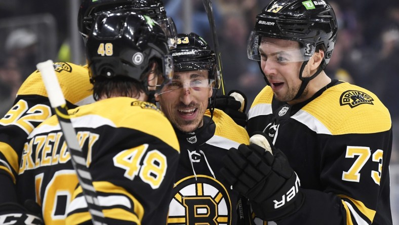 Jan 12, 2022; Boston, Massachusetts, USA; Boston Bruins left wing Brad Marchand (63) celebrates his goal with defenseman Charlie McAvoy (73) and defenseman Matt Grzelcyk (48) and left wing Tomas Nosek (92) during the first period against the Montreal Canadiens at TD Garden. Mandatory Credit: Bob DeChiara-USA TODAY Sports