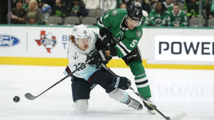 Jan 12, 2022; Dallas, Texas, USA; Seattle Kraken center Mason Appleton (22) and Dallas Stars defenseman Andrej Sekera (5) fight for a puck in the first period at American Airlines Center. Mandatory Credit: Tim Heitman-USA TODAY Sports
