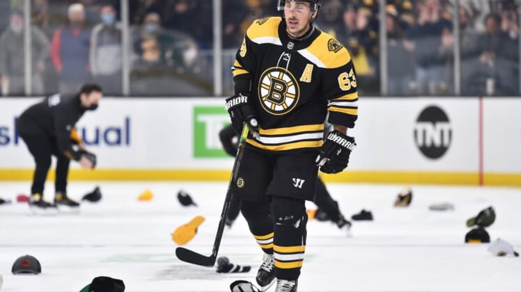 Jan 12, 2022; Boston, Massachusetts, USA; Boston Bruins left wing Brad Marchand (63) skates through a sea of hats after scoring his third goal of the game during the second period against the Montreal Canadiens at TD Garden. Mandatory Credit: Bob DeChiara-USA TODAY Sports
