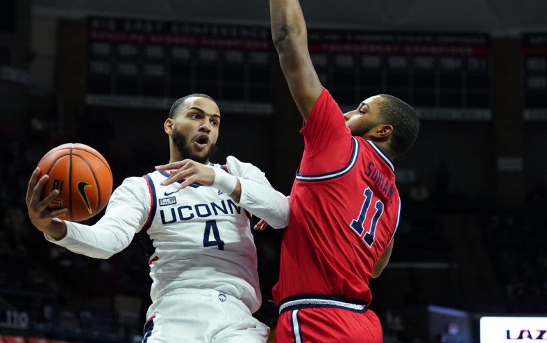 Jan 12, 2022; Storrs, Connecticut, USA; Connecticut Huskies guard Tyrese Martin (4) passs the ball against St. John's Red Storm center Joel Soriano (11) in the first half at Harry A. Gampel Pavilion. Mandatory Credit: David Butler II-USA TODAY Sports