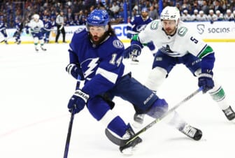 Jan 13, 2022; Tampa, Florida, USA; Tampa Bay Lightning left wing Pat Maroon (14) and Vancouver Canucks defenseman Tucker Poolman (5) skate to control the puck during the first period at Amalie Arena. Mandatory Credit: Kim Klement-USA TODAY Sports
