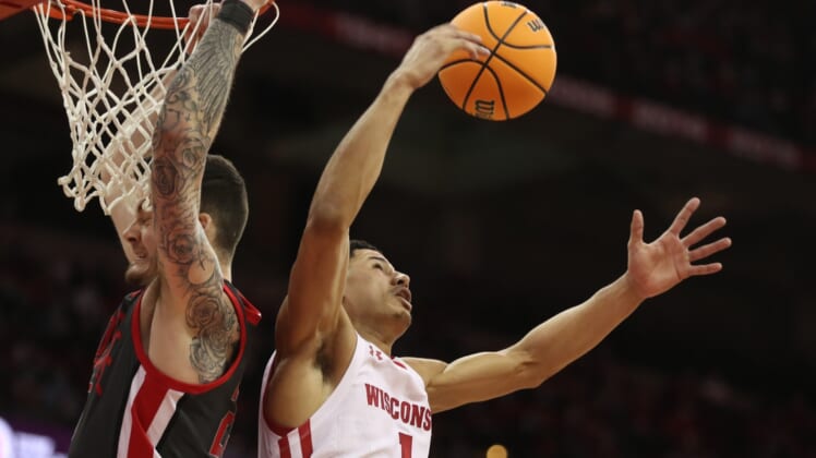Jan 13, 2022; Madison, Wisconsin, USA;Wisconsin Badgers guard Johnny Davis (1) grabs a rebound from Ohio State Buckeyes forward Kyle Young (25)  during the first half at the Kohl Center. Mandatory Credit: Mary Langenfeld-USA TODAY Sports