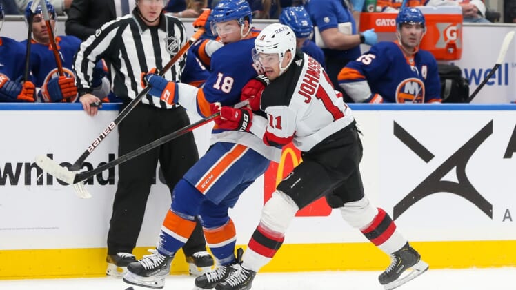 Jan 13, 2022; Elmont, New York, USA; New York Islanders left wing Anthony Beauvillier (18) and New Jersey Devils left wing Andreas Johnsson (11) battle for the puck during the first period at UBS Arena. Mandatory Credit: Tom Horak-USA TODAY Sports