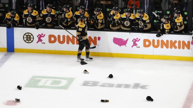 Jan 13, 2022; Boston, Massachusetts, USA; Hats litter the ice as Boston Bruins right wing David Pastrnak (88) is congratulated by teammates after scoring his third goal of the game against the Philadelphia Flyers during the second period at TD Garden. Mandatory Credit: Winslow Townson-USA TODAY Sports