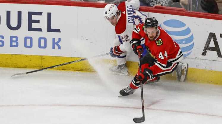 Jan 13, 2022; Chicago, Illinois, USA; Chicago Blackhawks defenseman Calvin de Haan (44) keeps the puck away from Montreal Canadiens right wing Cole Caufield (22) during the second period at United Center. Mandatory Credit: Kamil Krzaczynski-USA TODAY Sports