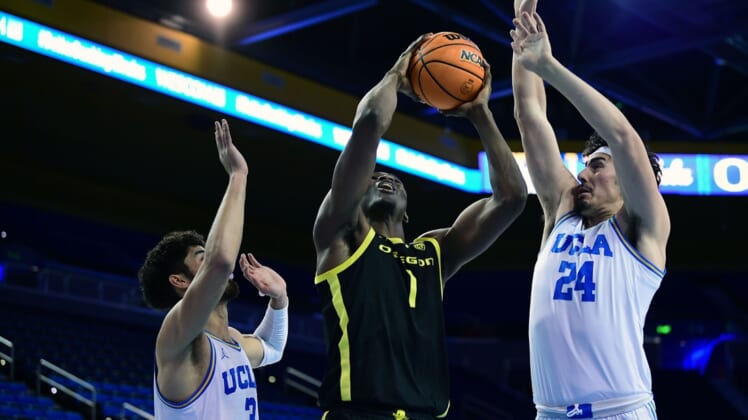 Jan 13, 2022; Los Angeles, California, USA; Oregon Ducks center N'Faly Dante (1) moves to the basket against UCLA Bruins guard Johnny Juzang (3) and guard Jaime Jaquez Jr. (24) during the first half at Pauley Pavilion. Mandatory Credit: Gary A. Vasquez-USA TODAY Sports