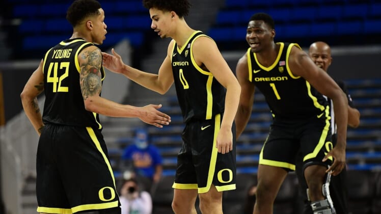 Jan 13, 2022; Los Angeles, California, USA; Oregon Ducks guard Jacob Young (42) celebrates with guard Will Richardson (0) and center N'Faly Dante (1) his basket scored against the UCLA Bruins during overtime at Pauley Pavilion. Mandatory Credit: Gary A. Vasquez-USA TODAY Sports