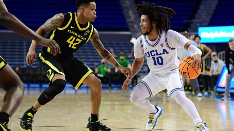 Jan 13, 2022; Los Angeles, California, USA; UCLA Bruins guard Tyger Campbell (10) controls the ball against Oregon Ducks guard Jacob Young (42) during the second half at Pauley Pavilion. Mandatory Credit: Gary A. Vasquez-USA TODAY Sports