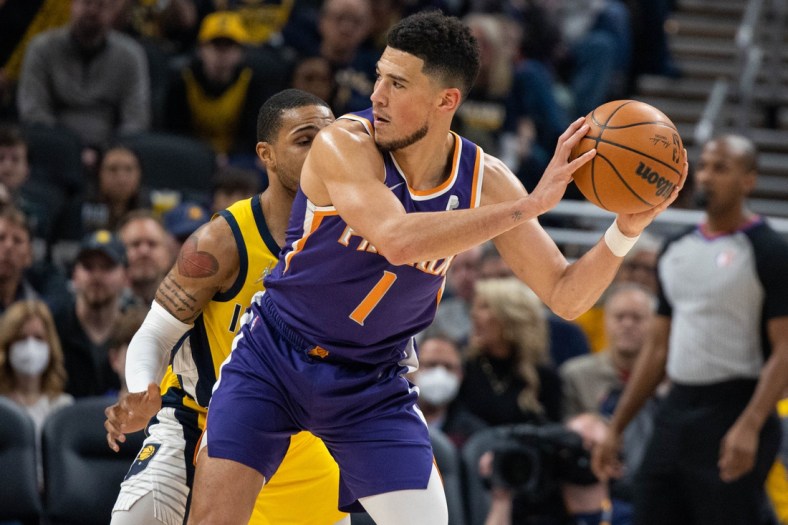 Jan 14, 2022; Indianapolis, Indiana, USA; Phoenix Suns guard Devin Booker (1) holds the ball while Indiana Pacers guard Keifer Sykes (28) defends in the first quarter at Gainbridge Fieldhouse. Mandatory Credit: Trevor Ruszkowski-USA TODAY Sports