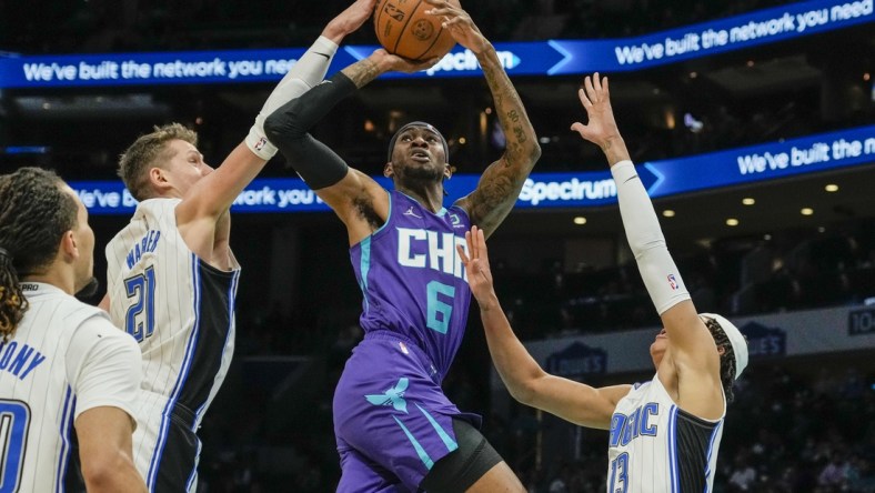 Jan 14, 2022; Charlotte, North Carolina, USA; Charlotte Hornets forward Jalen McDaniels (6) tries to fight pressure from  Orlando Magic guard R.J. Hampton (13) and center Moritz Wagner (21) during the second quarter at the Spectrum Center. Mandatory Credit: Jim Dedmon-USA TODAY Sports