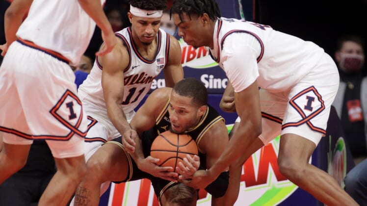 Jan 14, 2022; Champaign, Illinois, USA;  Michigan Wolverines guard DeVante' Jones (12) holds on to the ball as Illinois Fighting Illini guard Alfonso Plummer (11) and teammate Omar Payne (4) reach for it during the first half at State Farm Center. Mandatory Credit: Ron Johnson-USA TODAY Sports