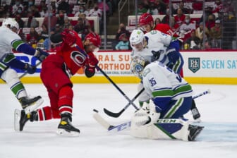 Jan 15, 2022; Raleigh, North Carolina, USA;  Carolina Hurricanes center Jordan Staal (11) and center Steven Lorentz (78) battle over the puck against Vancouver Canucks goaltender Thatcher Demko (35) and defenseman Tyler Myers (57) during the first period at PNC Arena. Mandatory Credit: James Guillory-USA TODAY Sports