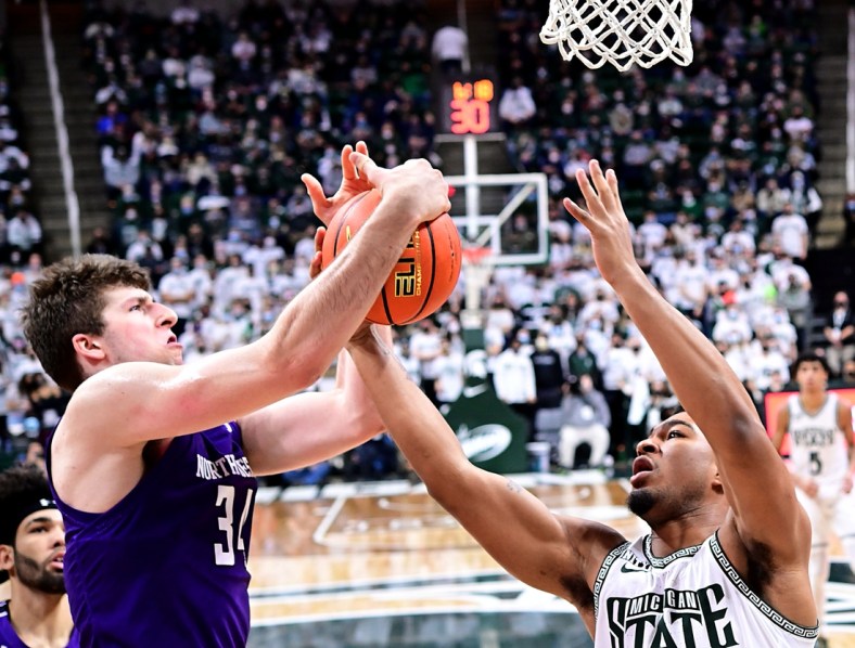 Jan 15, 2022; East Lansing, Michigan, USA;  Northwestern Wildcats center Matthew Nicholson (34) battles with Michigan State Spartans guard Pierre Brooks (1) for a rebound in the second half at Jack Breslin Student Events Center. Mandatory Credit: Dale Young-USA TODAY Sports