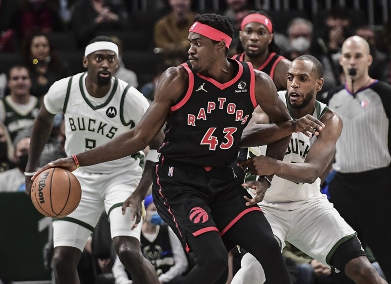 Jan 15, 2022; Milwaukee, Wisconsin, USA; Toronto Raptors forward Pascal Siakam (43) is guarded by Milwaukee Bucks center Bobby Portis (9) and forward Khris Middleton (22) in the first quarter at Fiserv Forum. Mandatory Credit: Benny Sieu-USA TODAY Sports