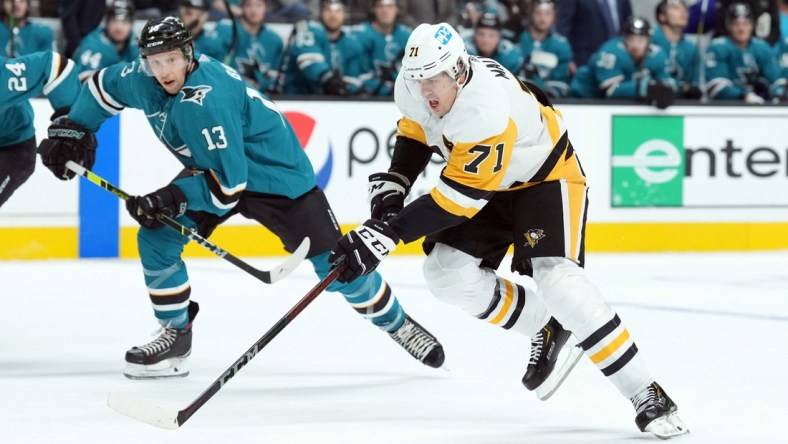 Jan 15, 2022; San Jose, California, USA; Pittsburgh Penguins center Evgeni Malkin (71) skates with the puck as San Jose Sharks center Nick Bonino (13) pursues during the first period against the San Jose Sharks at SAP Center at San Jose. Mandatory Credit: Darren Yamashita-USA TODAY Sports