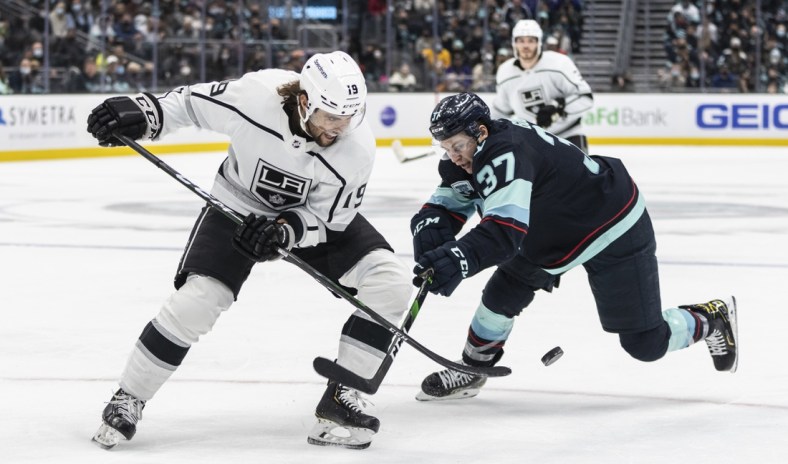 Jan 15, 2022; Seattle, Washington, USA;  Los Angeles Kings left wing Alex Iafallo (19) and Seattle Kraken center Yanni Gourde(37) battle for the puck during the second period at Climate Pledge Arena. Mandatory Credit: Stephen Brashear-USA TODAY Sports