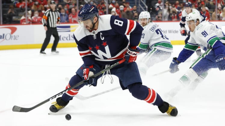Jan 16, 2022; Washington, District of Columbia, USA; Washington Capitals left wing Alex Ovechkin (8) controls the puck as Vancouver Canucks left wing Juho Lammikko (91) defends during the first period at Capital One Arena. Mandatory Credit: Geoff Burke-USA TODAY Sports